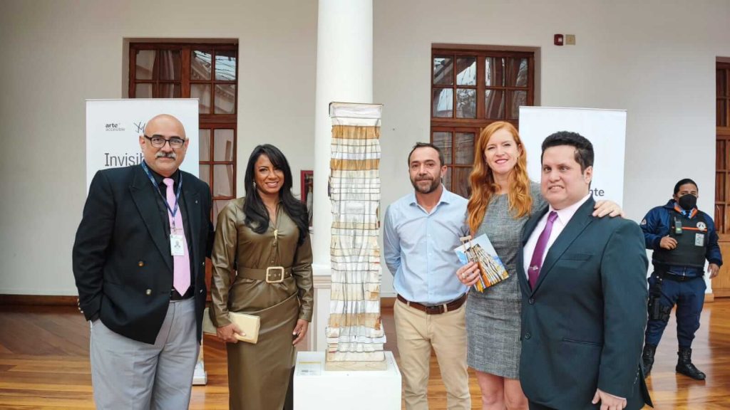 Photo in which Jeimy Hernández, a piece of art part of the exhibition (Legal Support Legal 3), Andrés Julio, Lorena Julio y Sebastián Flores appear from left to right.