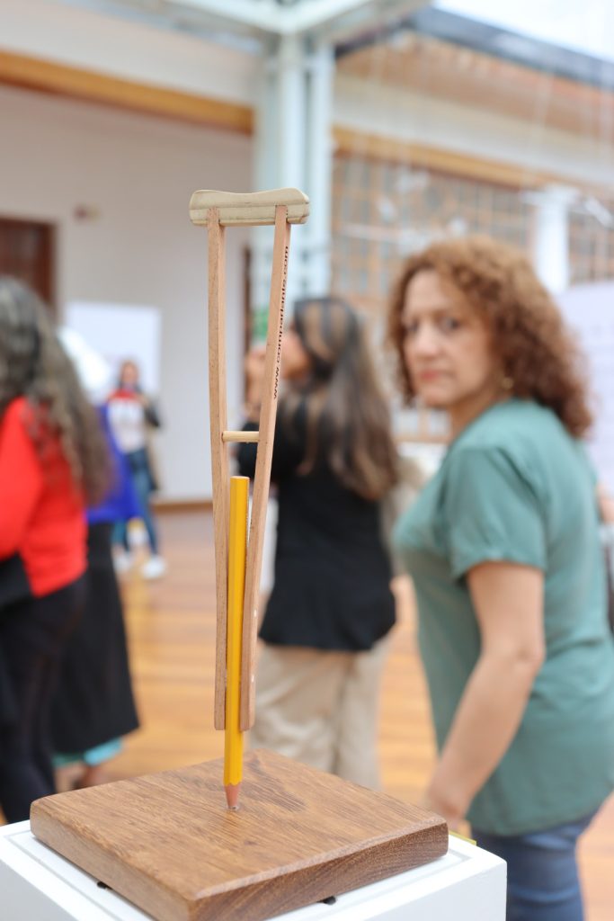 "Close-up photo of the artwork "Soporte Legal #1" with several people blurred in the background, appreciating the exhibition."